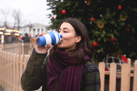 Pretty woman holding reusable coffee cup