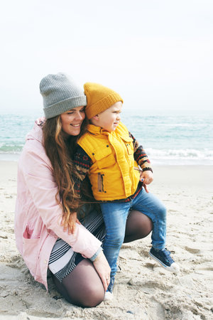 Mother and son spending time together on the beach in sunny spring dayの写真素材