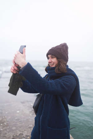 Beautiful woman walking on the beach with seagulls in winter time. Free spirit conceptの写真素材