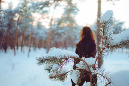 Young woman enjoying winter weather in the snow forest. cold weather. Winter holidays, rest, travel concept.の写真素材