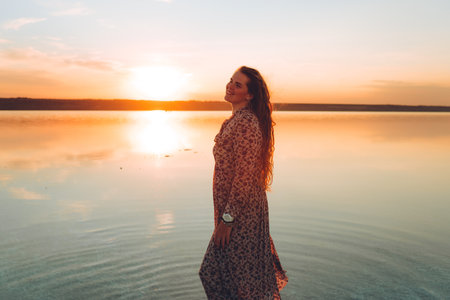 Portrait happy laughing woman in pink dress playful having fun on desert beach of salt pink lake. Ukrainian salt lakeの写真素材