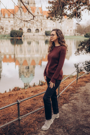 Happy woman posing in red sweater in the park by the New Town Hall in Hannover, Germany.の写真素材