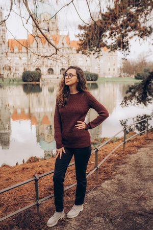 Happy woman posing in red sweater in the park by the New Town Hall in Hannover, Germany.の写真素材