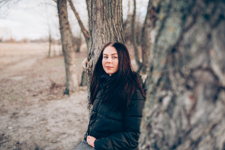 Portrait of young smiling brunette woman in winter jacket looking at camera.の写真素材