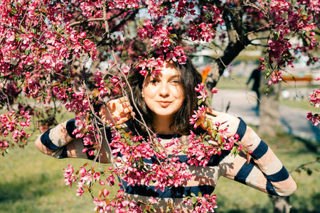 Beautiful happy young woman enjoying smell in a flowering spring garden.の写真素材