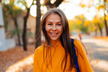 Portrait of a happy smiling young woman while walking outdoors.の写真素材