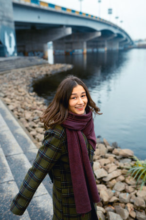Young brunette woman smiling while walking outdoors.の写真素材