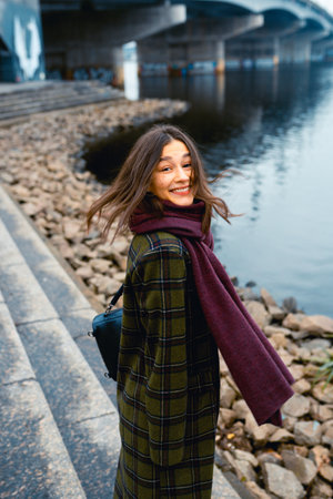 Young brunette woman smiling while walking outdoorsの写真素材