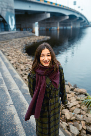 Young brunette woman smiling while walking outdoorsの写真素材