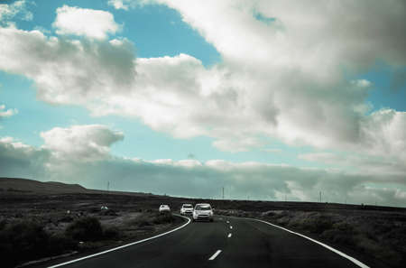 one road at the Lanzarote island, blue sky, clouds and cars coming onのeditorial素材