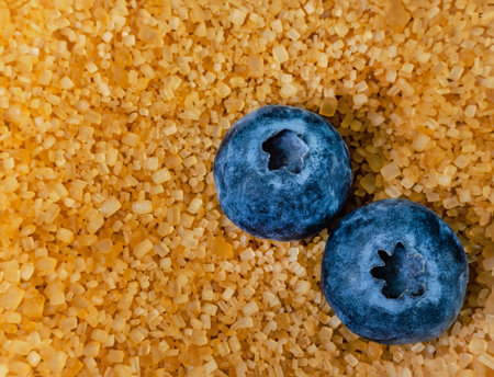 dark blue blueberry, macro shot very close on yellow bamboo sugar background isolatedの写真素材