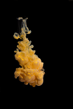 Golden pearl Ink dropped into the water and photographed while in motion. Paint swirling in water....