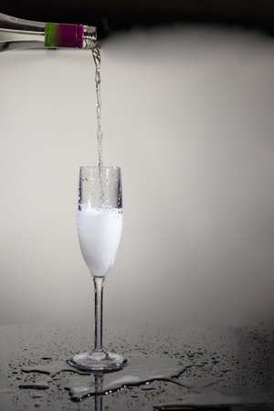 champagne is poured from a bottle into glass. wine festive conceptの写真素材