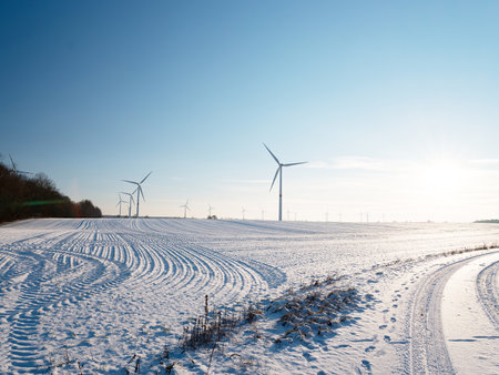 Wind turbines and agricultural field on winter day.Green Energy production clean and renewable. Ecological and climate crisis concept. winter landscape in Germanyの写真素材