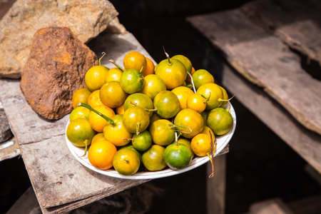 green and yellow oranges tropical fruits in outdoor market in Sri-Lanka for sale close-up on a...