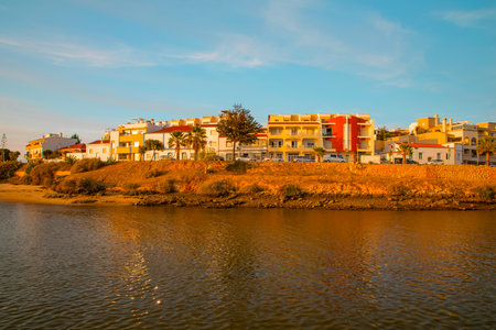 Faro, Portugal 26 September 2020. small traditional fishing village of Ferragudo on the river bank with white houses with tiled roofs in summer on a sunny day. view from the oceanの写真素材