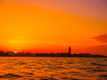 Venice, Italy. 29 october 2022. silhouettes of Venice at sunset in the bright warm orange-red rays of the setting sun. view from the waterの写真素材