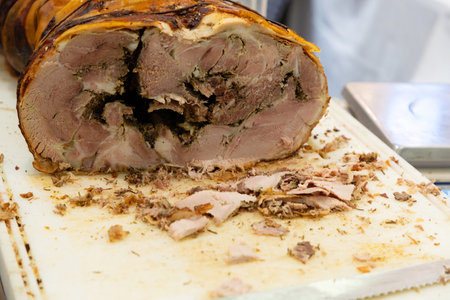 a large loaf of fresh ham and sausage ready for sale and cut into pieces for samplingの写真素材