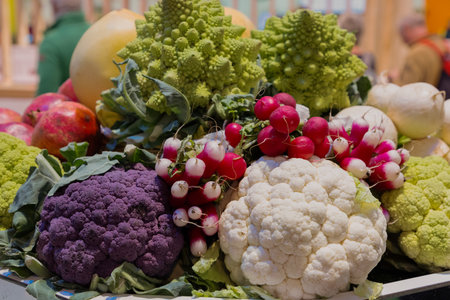 Vibrant display of assorted vegetables featuring cauliflower, radishes, and romanesco, showing...