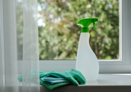 Cleaning agent, wipes and rubber gloves on the windowsill. General cleaning concept