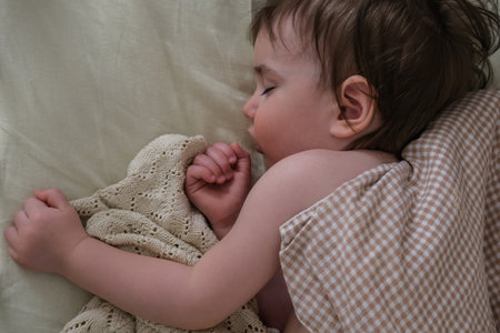 One year old baby sleeps sweetly in the cribの写真素材