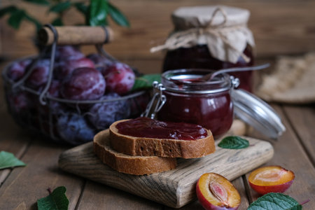 Homemade plum jam and fresh berries on a wooden background. Homemade protection concept. Summer...