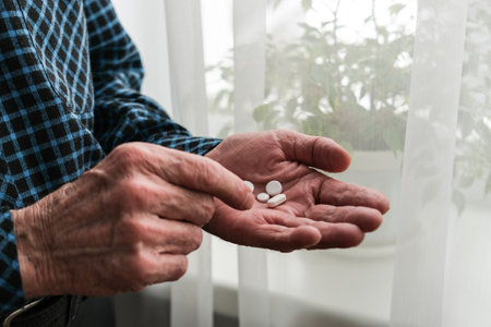 Many multi-colored pills in a Senior's hands. Painful old age. Caring for the health of the elderlyの写真素材