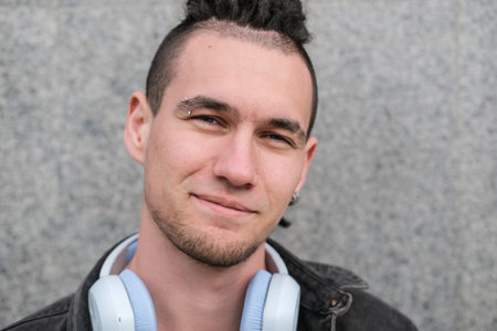 Portrait of a young smiling guy with dreadlocks and piercings