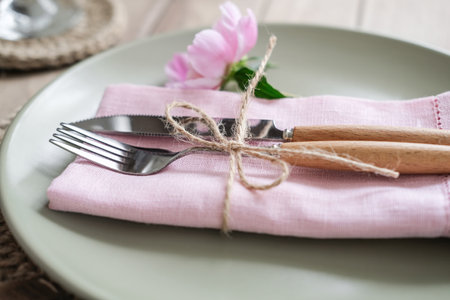 Close up cutlery. Romantic table setting with pink peonies