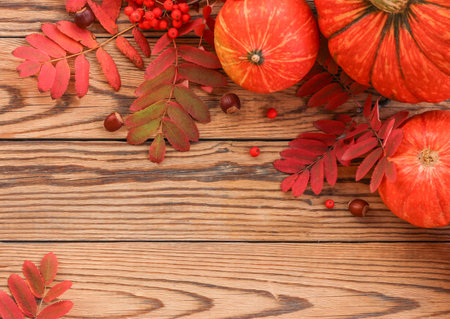 Autumn flatlay with pumpkins and fallen leaves on a wooden background. Place for text. Thanksgiving and Halloween postcard template.の写真素材