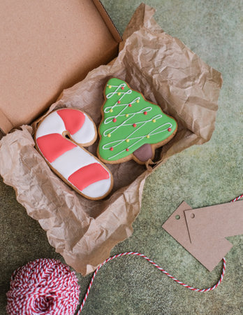 Christmas gingerbread cookies in the shape of a tree and a cane in gift boxesの写真素材