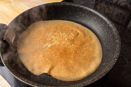 Frying cooking pancake on a frying pan. Home cookingの写真素材