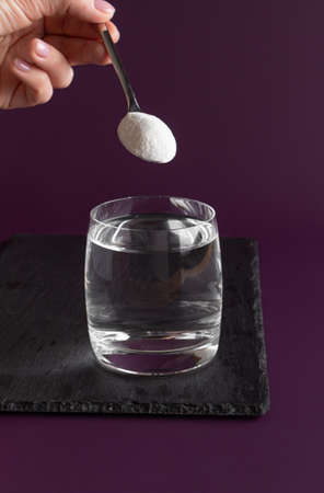 Woman adding putting collagen into water. health care