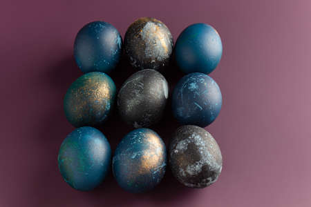 Dyed easter eggs with with beautiful flowers on a purple background. Patternの写真素材