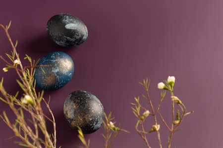 Dyed easter eggs with with beautiful flowers on a purple background. Patternの写真素材