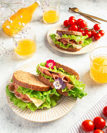 sandwich with ham, cheese and lettuce leaves on a gray background. Home cookingの写真素材