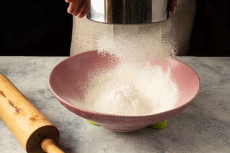 chef woman is sifting flour. Home cokingの写真素材
