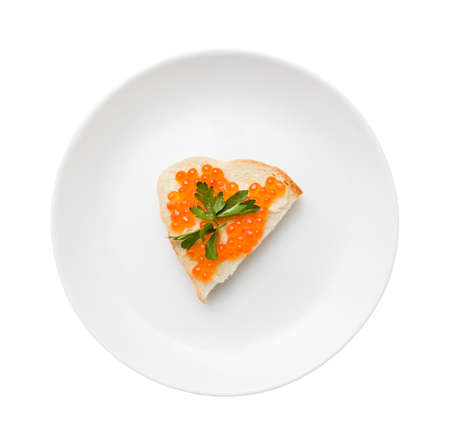 sandwich with red caviar and butter on a plate isolated on white backgroundの写真素材