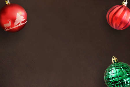 Christmas red, wavy and green ribbed balls on dark wooden table. Top view.