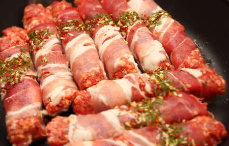 Chevapchichi meat in bacon roasting in a pan. Photo with bokeh effect.の写真素材