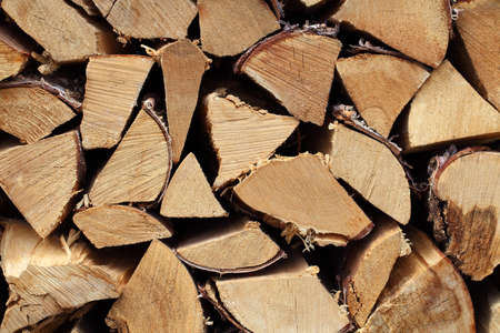 Hardwood firewood split logs stacked in a pile, an end view.