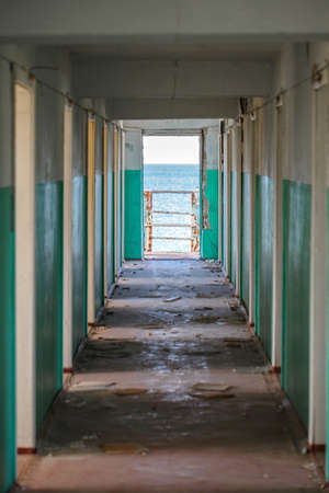 Corridor with doors in an abandoned building during the day and sea view.の写真素材