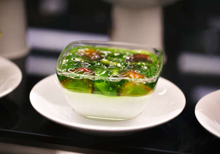 Jelly in a bowl of kiwis with strawberries, on a plateの写真素材