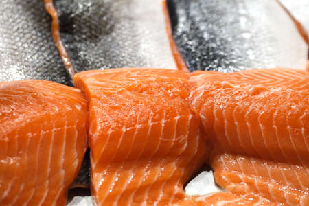 Salmon fish fillet on ice, fresh raw pieces chilled, at the fish market.の写真素材