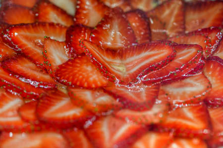 Strawberries cut into flat slices in sweet clear syrupの写真素材