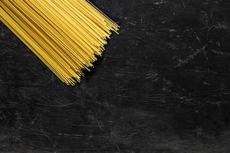 Macaroni spaghetti raw, bundle, top view dark background, with space to copy text.の写真素材