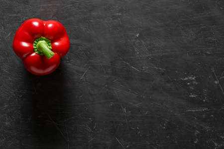 Pepper sweet red bulgarian one, on dark background, top view, with space to copy text.