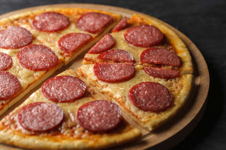 Pepperoni pizza cut into conical pieces on wooden stand, selective focus.の写真素材