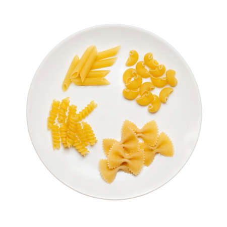 Pipe rigate, farfalle, fusilli, penne pasta raw, set on white plate isolated on white backgroundの写真素材