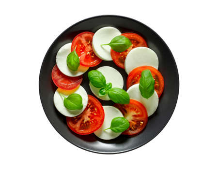 Caprese, Italian appetizer on dark gray plate, isolated on white background with clipping path.の写真素材